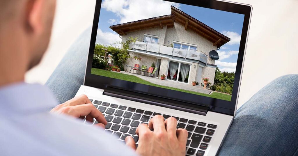 A man sits at home on his laptop and has the value of his property assessed using an online tool | Real estate valuation