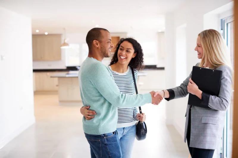 depositphotos 299152912 stock photo female realtor shaking hands couple 1